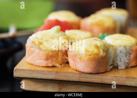 Warme Brötchen mit Ingwer, Wasabi und Lachs auf einem Stand aus Holz close-up Stockfoto