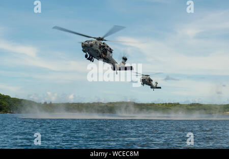 190827-N-QL 471-1011 Santa Rita, Guam (Aug. 27, 2019) MH-60S Seahawk Hubschrauber, auf der "Insel der Ritter" Hubschrauber Meer Combat Squadron (HSC) 25, U.S. Marines, 3 Reconnaissance Bataillon zugeordnet, 3rd Marine Division und 3Rd Marine Division, die Beseitigung von Explosivstoffen 1 Platoon, und Mitglieder von Her Majesty's Neuseeland Schiff Matataua (HEMIGRAMMUS Matataua) während einer helocasting Experte Wissensaustausch als Teil der Übung HYDRACRAB. HYDRACRAB ist ein viereck Übung durch Kräfte aus Australien, Kanada, Neuseeland, und U.S. Naval Forces. Die Purpos Stockfoto