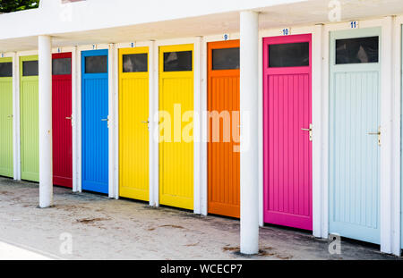 Zeile der öffentlichen Umkleidekabinen mit bunten Türen auf den Strand von Trestraou in Trégastel, Bretagne, Frankreich. Stockfoto