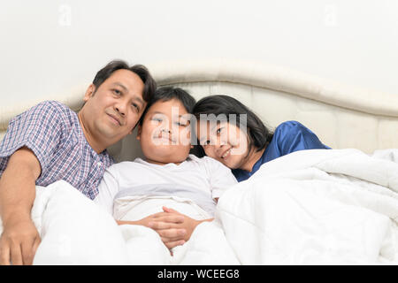 Glückliche Familie, Mutter, Vater oder Mutter und Sohn auf dem Bett liegend, Liebe und Sorgfalt Konzept Stockfoto