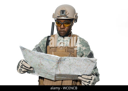 Vorderansicht des amerikanischen Soldaten tragen gelbe Gläser und einheitliche Holding Karte und suchen an der Lokalität Objekte. Afrikanische Mann Soldat in der Rüstung navigieren mit Karte. Stockfoto