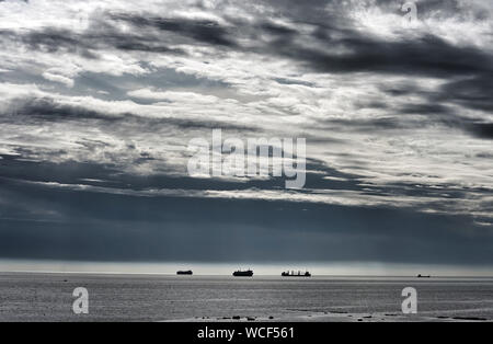 Schiffe auf See, wie Gewitterwolken roll im Off, die Küste von Whitley Bay. Stockfoto