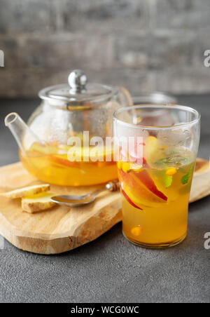 Glas Tasse Kaffee und Teekanne auf grauem Hintergrund Stockfoto