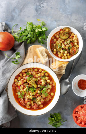 Vegan Kichererbsen Eintopf mit Tomaten auf grauem Hintergrund Stockfoto