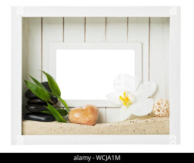 Holz Bilderrahmen mit Spa und zen Symbole - bambusblätter, Orchidee, herzförmige Kiesel, Sand gefüllt, Massage Steine. Isolierte w/Freistellungspfad Stockfoto