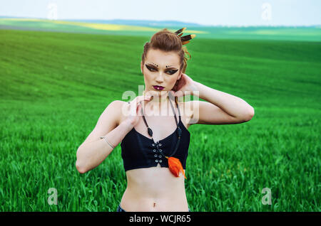 Aggressive Make-up Girl, amazon Charakter in ein grünes Weizenfeld. Feminismus, der Unabhängigkeit, der Stamm. Stockfoto