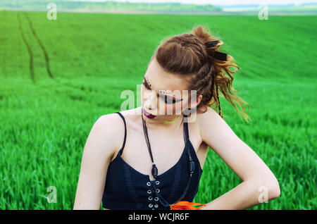 Aggressive Make-up Girl, amazon Charakter in ein grünes Weizenfeld. Feminismus, der Unabhängigkeit, der Stamm. Stockfoto