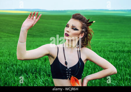 Aggressive Make-up Girl, amazon Charakter in ein grünes Weizenfeld. Feminismus, der Unabhängigkeit, der Stamm. Stockfoto