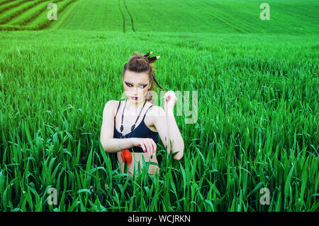 Aggressive Make-up Girl, amazon Charakter in ein grünes Weizenfeld. Feminismus, der Unabhängigkeit, der Stamm. Stockfoto