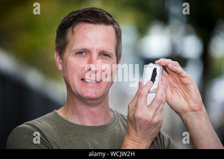 Treasure Hunter Michael Thompson eine Holding gefaltet Wikingerzeit silbernen Arm-Ring am 9. und 10. Jahrhunderts Datum, die er im Bereich der Ballinderry Co Antrim mit einem Metalldetektor gefunden. Stockfoto