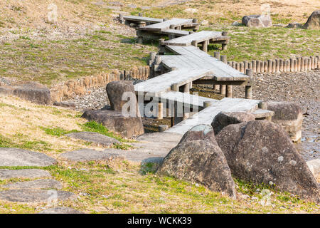 Holzbrücke im Zickzack auf trockenen Teich im Japanischen Garten. Dürre Stockfoto