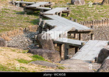 Holzbrücke im Zickzack auf trockenen Teich im Japanischen Garten. Dürre Stockfoto