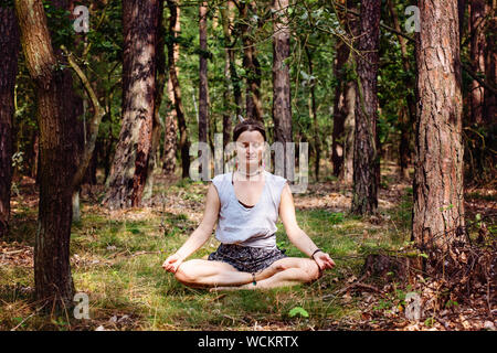 Junge Frau allein Meditieren und leise im Sommer Wald Stockfoto