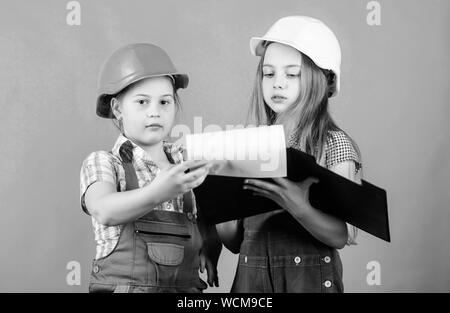 Kleine Mädchen zusammen die Reparatur in der Werkstatt. Schulprojekt. Glückliche Kinder. Kleine Kinder im Helm mit Tablet. Tag der Arbeit. 1. Mai. Meister Inspektor. Reparatur. building Workshop. workshop Arbeitnehmer. Stockfoto