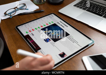 Badewanne, Großbritannien - 28 August, 2019: Person, die mit einem Apple iPad Pro auf einem Schreibtisch anzeigen Börse Informationen mithilfe des Apple Aktien App. Die Seite zeigt Stockfoto