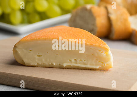 Stück cremige Französische Chaumes Käse auf einem Schneidebrett Nahaufnahme Stockfoto