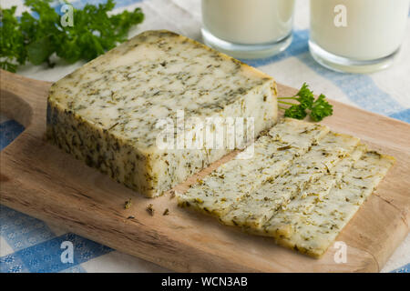 Stück Reifen niederländische Ziegenkäse mit Kräutern zum Mittagessen Stockfoto