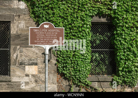 Pocken Krankenhaus Roosevelt Island, eine touristische Informationstafel außerhalb der ruiniert Pocken Krankenhaus Gebäude auf Roosevelt Island, New York City, USA Stockfoto