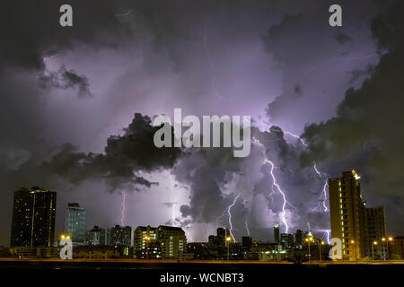 Stadt Landschaft Gewitter hinter Wolken bei Nacht Stockfoto