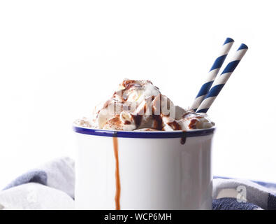 Nahaufnahme von einem weißen Tasse heiße Schokolade mit Sahne und zwei Papier Trinkhalme. Stockfoto