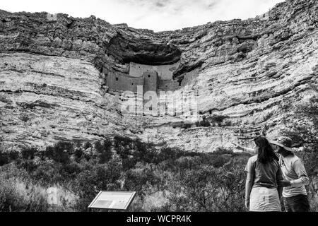 Montezuma Castle an einem bewölkten Tag mit ein paar Besucher, die versuchen, herauszufinden, wo die Leute ihre sinagua Cliff Wohnung eingetragen. Stockfoto