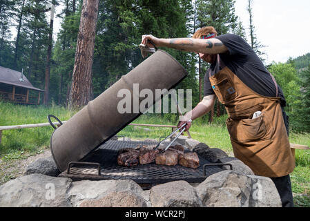 Kochen Schweinelende über einem Feuer am Minam River Lodge in Oregon Wallowa Mountains. Stockfoto