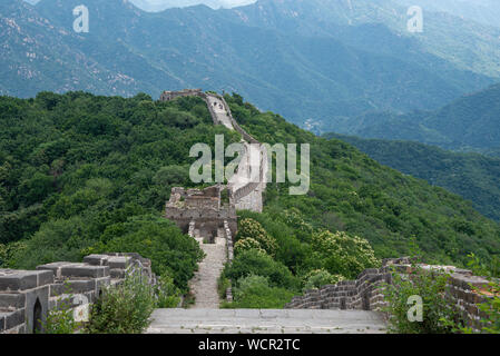 Touristische Menschen gehen an die berühmte chinesische Mauer, eines der sieben Wunder der Welt bei Mutianyu in China Stockfoto