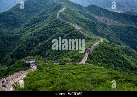 Touristische Menschen gehen an die berühmte chinesische Mauer, eines der sieben Wunder der Welt bei Mutianyu in China Stockfoto