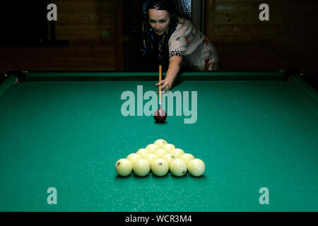 Ältere Frau brechen die in Triangle Billardkugeln, auf Billard und Russisches Billard zu starten. Selektive konzentrieren. Close-up. Stockfoto