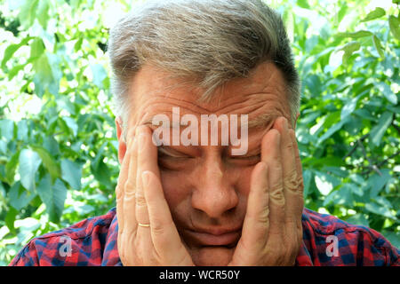 Porträt einer stattlichen, müde, gestresste, älterer Mann, der reibt seine Augen mit den Fingern. Gestresst, müde, erschöpft. Selektive Weichzeichner. Close-u Stockfoto