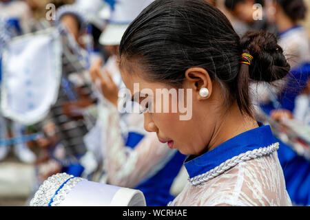 Filipino Sekundärschoolgirls machen Sie sich bereit, in der Tambor Trumpa Martsa Musika (Drum & Bugle) Contest, Dinagyang Festival, Iloilo, Philippinen zu konkurrieren Stockfoto