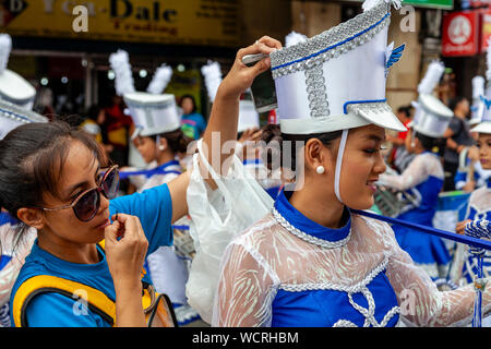 Filipino Sekundärschoolgirls machen Sie sich bereit, in der Tambor Trumpa Martsa Musika (Drum & Bugle) Contest, Dinagyang Festival, Iloilo, Philippinen zu konkurrieren Stockfoto