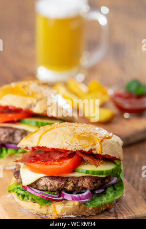 Hausgemachte Burger auf dunklem Holz Stockfoto