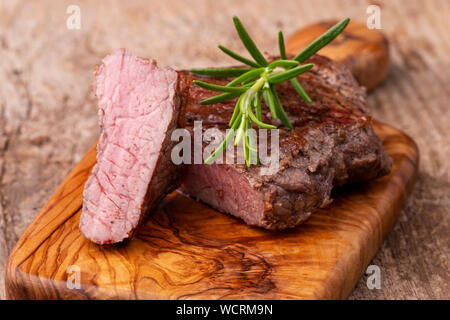 Gegrilltes Steak auf Holz mit Rosmarin Stockfoto