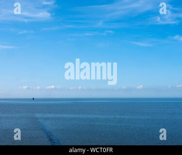 Einsame alte hölzerne Segelschiff auf Wattenmeer Norden der Niederlande unter blauem Himmel im Sommer Stockfoto