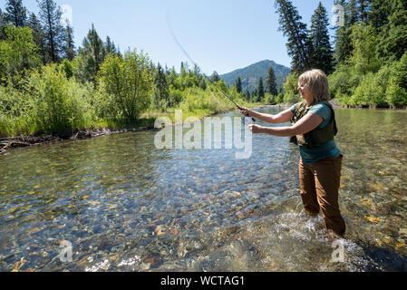 Frau Angeln in Minam Fluss, Wallowa Mountains, Oregon. Stockfoto