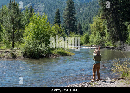 Frau Angeln in Minam Fluss, Wallowa Mountains, Oregon. Stockfoto