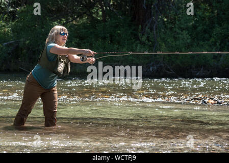 Frau Angeln in Minam Fluss, Wallowa Mountains, Oregon. Stockfoto