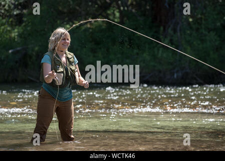 Frau Angeln in Minam Fluss, Wallowa Mountains, Oregon. Stockfoto