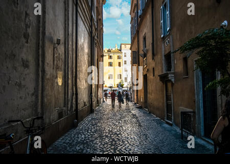 Ein paar Spaziergänge in einer engen Gasse in Richtung der Piazza Navona in Rom, Italien. Stockfoto