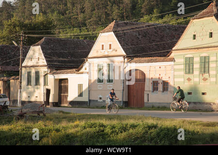 Radfahrer und Häuser an der Hauptstraße in Malancrav Dorf, Siebenbürgen, Rumänien Stockfoto