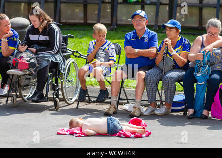 Warrington Wolves die Koralle Challlenge Cup wieder Zuhause - ein Kind schläft und man wählt seine Nase Stockfoto