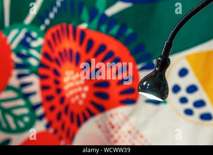 Schwarz flexible Leuchte auf dem Hintergrund der farbigen Gewebe. Stockfoto