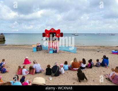 Swanage, England. 28 Aug, 2019. Menschen auf Swanage Beach sehen Sie sich das Kasperletheater, wie Wolken Bubble Up hinter in Swanage, Dorset, am 28. August 2019. Credit: Paul Marriott/Alamy leben Nachrichten Stockfoto