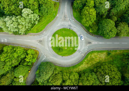 Von oben nach unten Antenne drone Blick auf einen kleinen Kreisverkehr an einer ruhigen Straße Stockfoto