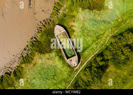 Antenne drone Ansicht von Schlick gefüllt Wracks der abgebrochenen Boote verwendet, um Erosion zu verringern, an den Ufern des Flusses Severn in England (purton Wracks) Stockfoto