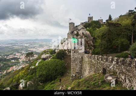 Blick auf einen Abschnitt der mittelalterlichen steinernen Verteidigungsmauern und Türme der Burg der Mauren (Castelo dos Mouros) in Sintra, Portugal. Stockfoto