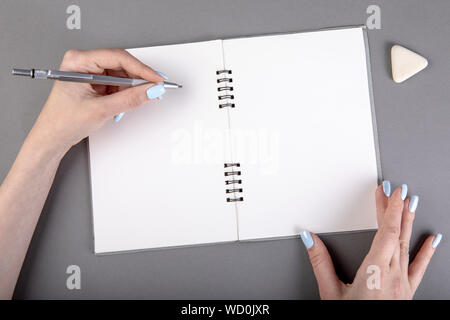 Frau hand mit Bleistift zu schreiben auf Notebook Stockfoto
