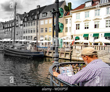 Bunte Boote und Häuser mit Maler am Nyhavn Kanal in Kopenhagen Dänemark Stockfoto