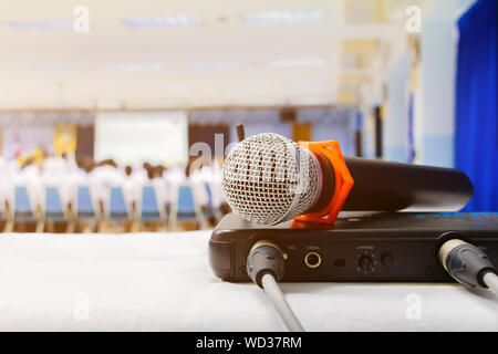 Nahaufnahme alten Mikrofon wireless mit Box Signal am weißen Tisch in Business Konferenz innen Seminar Tagungsraum und unscharfen Hintergrund Stockfoto